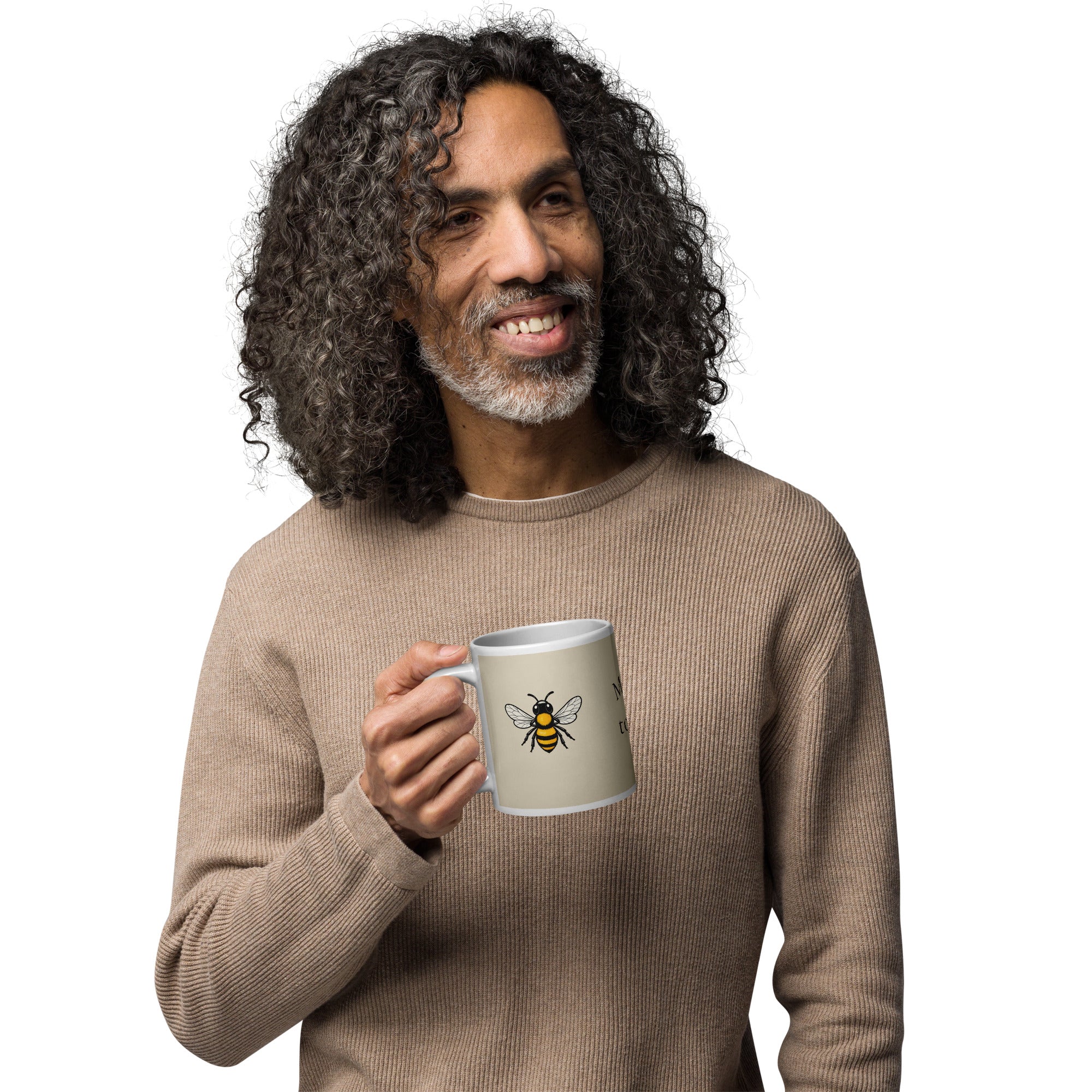 Light beige ceramic coffee mug with bee illustration, held near chest