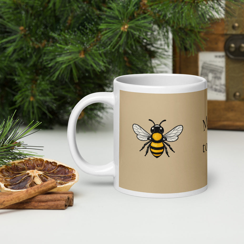 Beige ceramic coffee mug with bee illustration and white handle