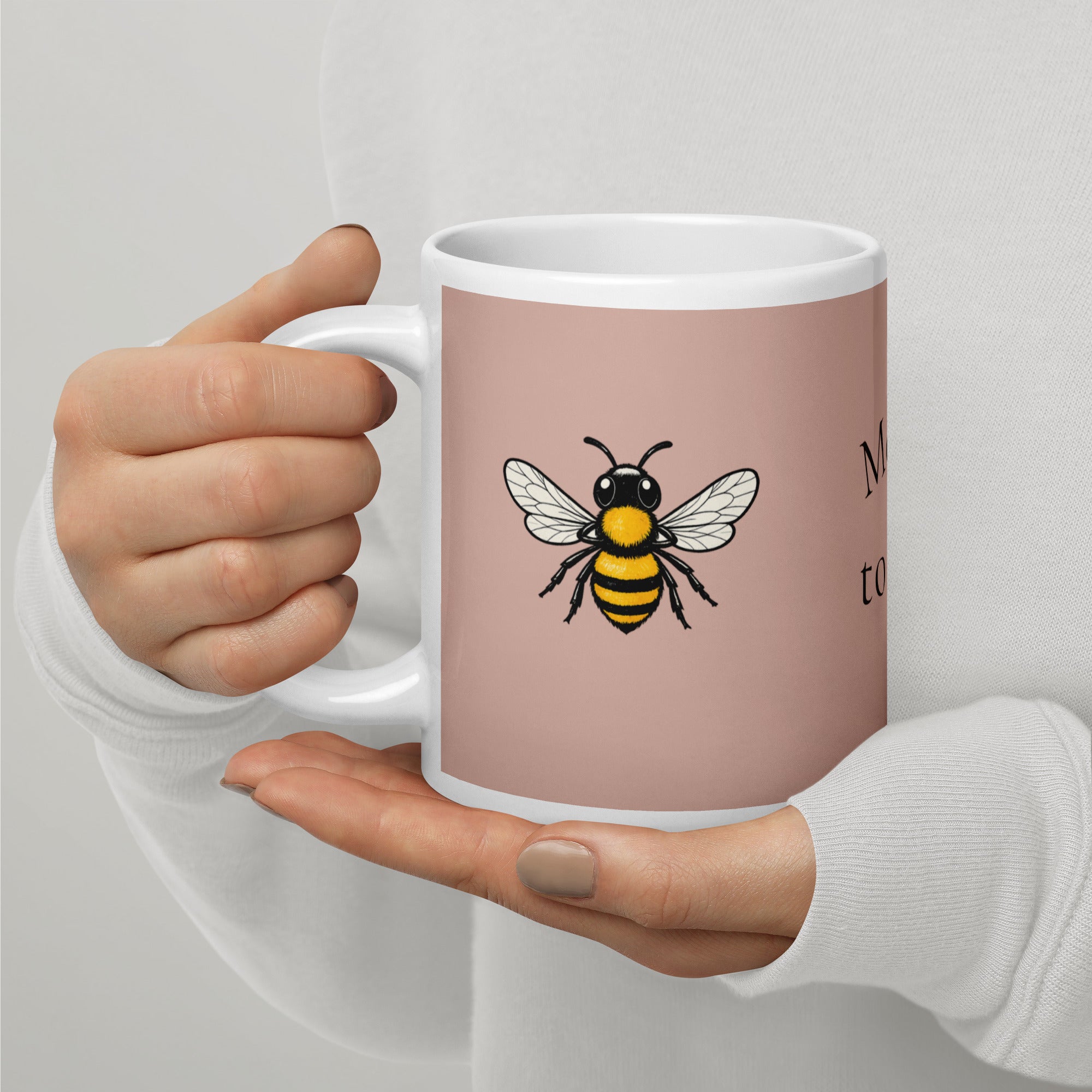 Dusty rose ceramic coffee mug with bee illustration, white rim and handle