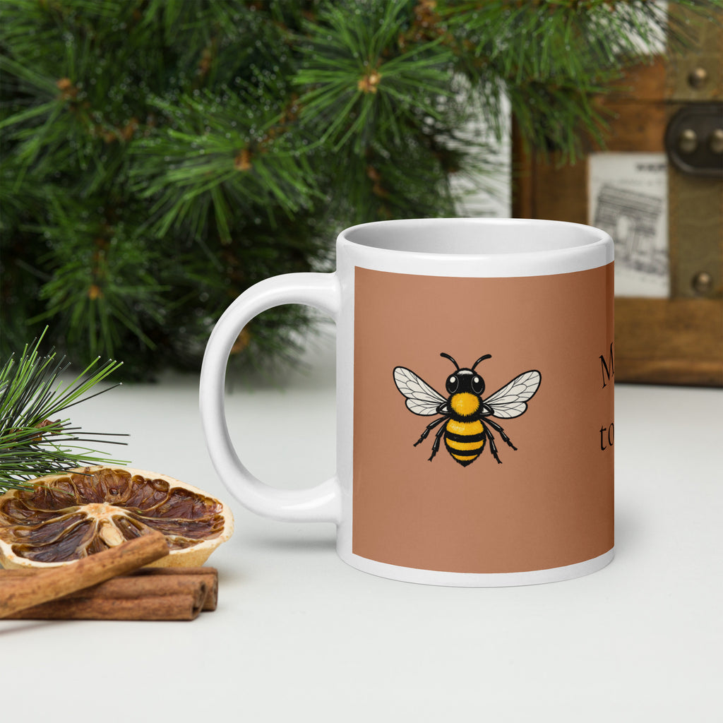 Brown ceramic coffee mug with bee graphic and white interior, side view