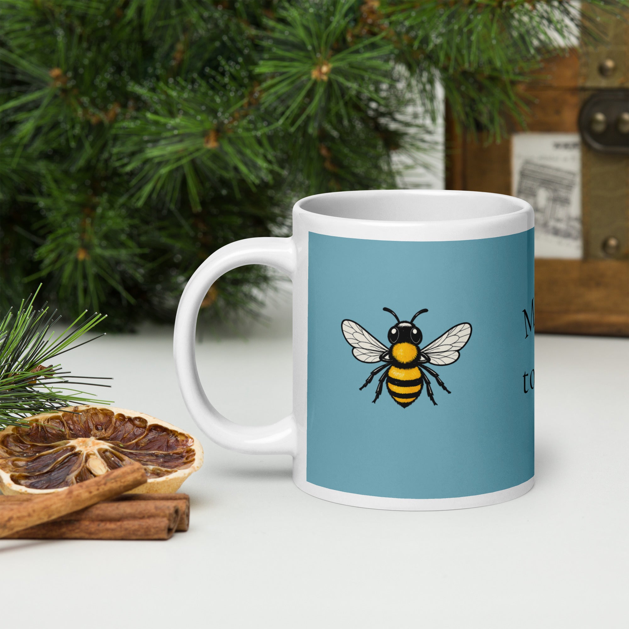 Blue ceramic mug with bee illustration on the front, white handle visible