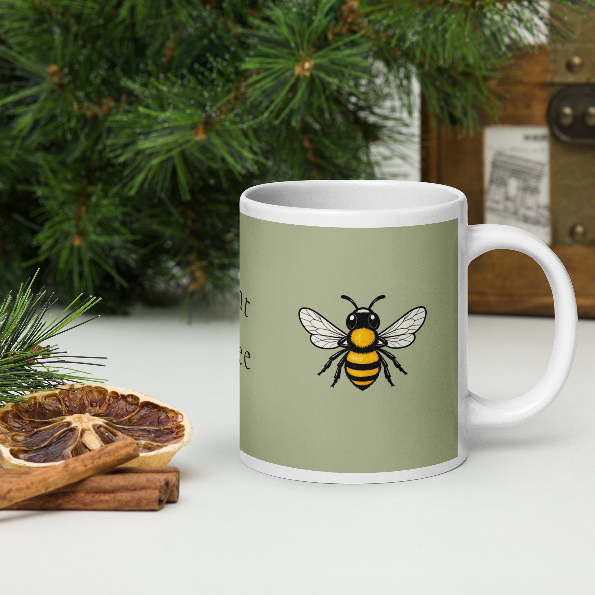Sage green ceramic mug with white handle and bee illustration