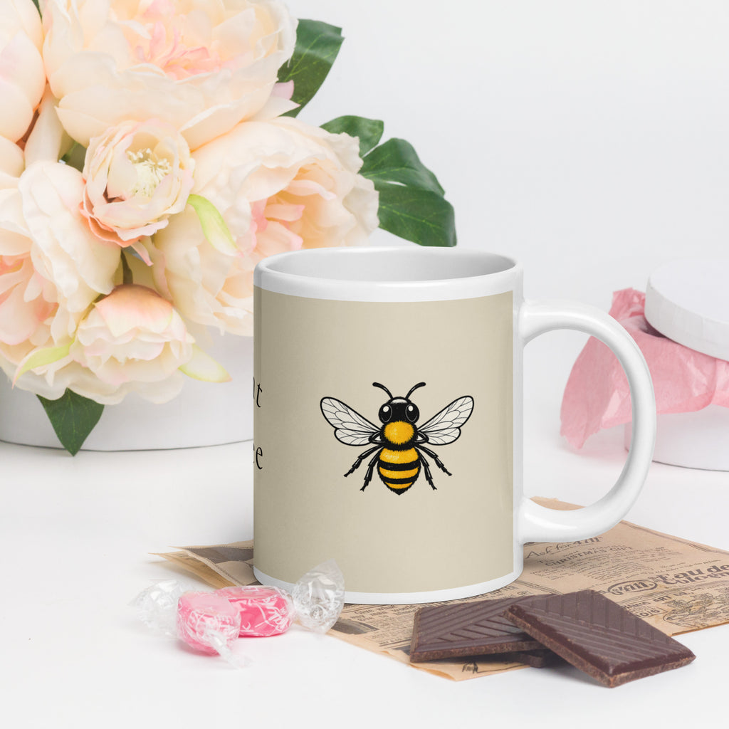 Light beige ceramic mug with bee illustration and side handle view