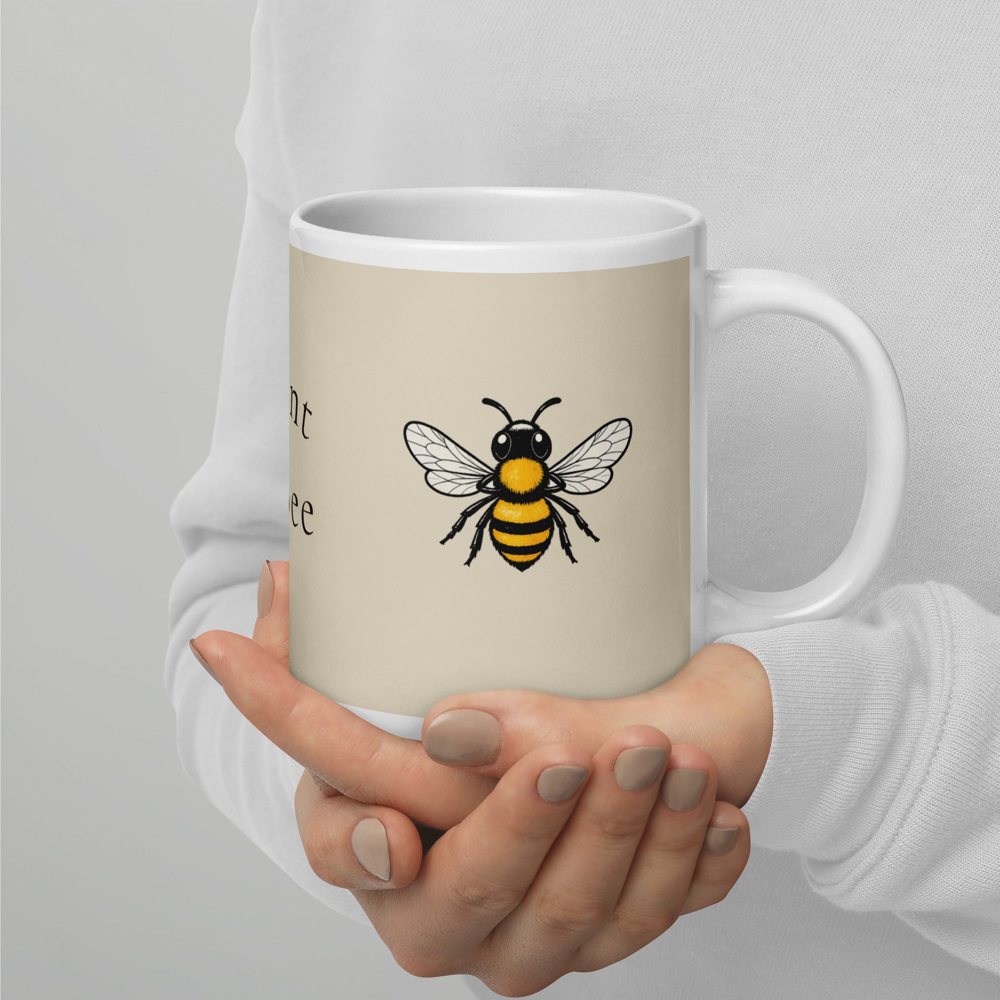 Light beige ceramic coffee mug with black and yellow bee illustration on side