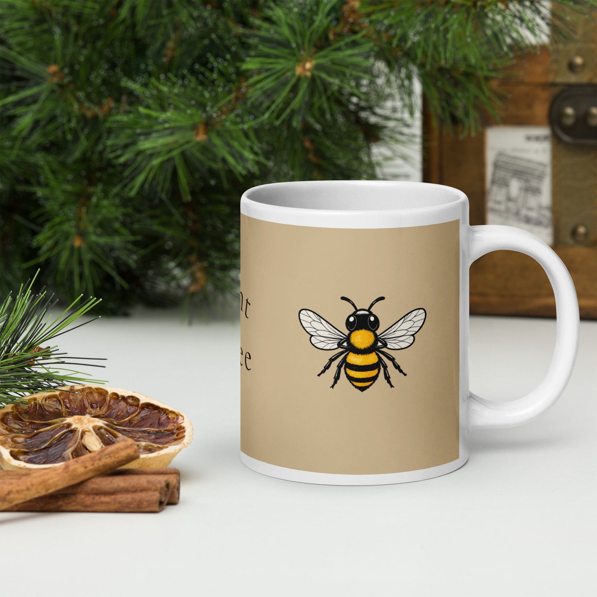 Beige ceramic coffee mug with centered bee illustration and white handle