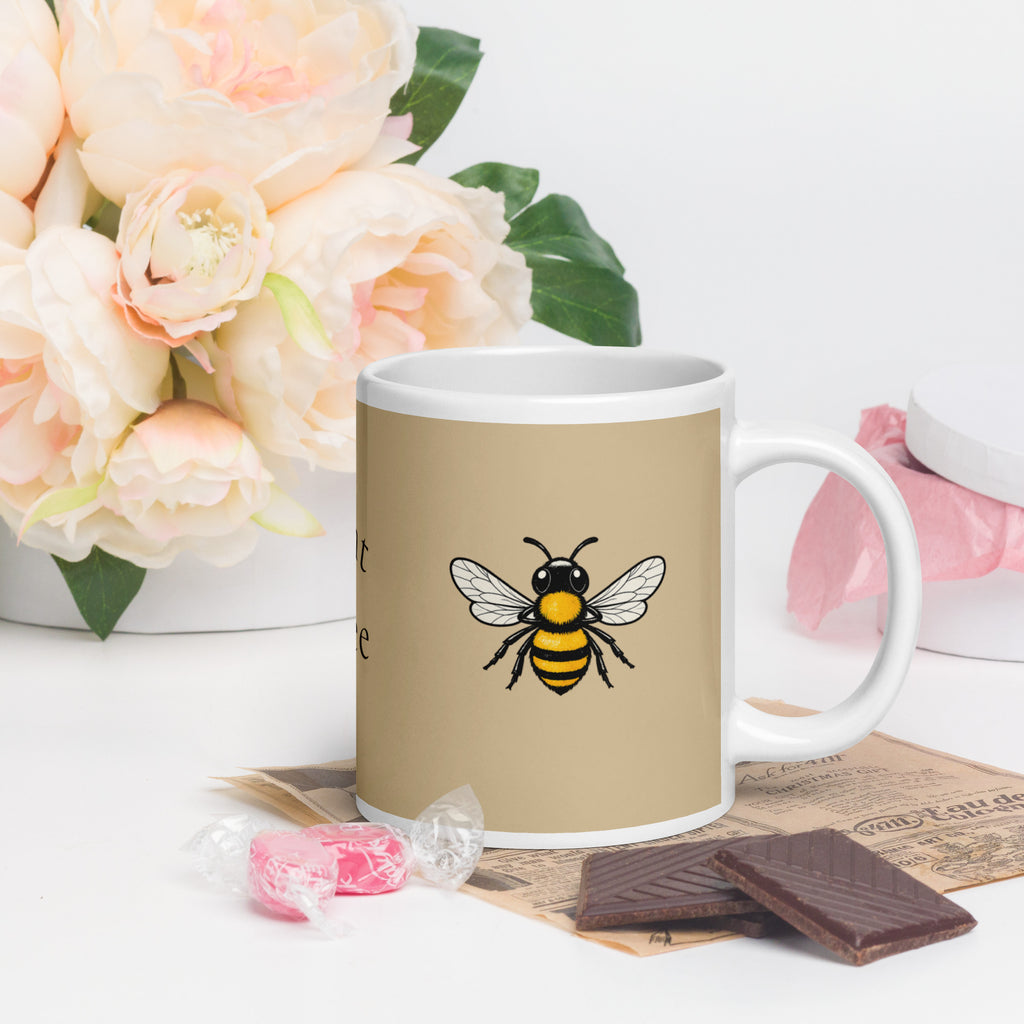 Beige ceramic mug with bee illustration and white handle