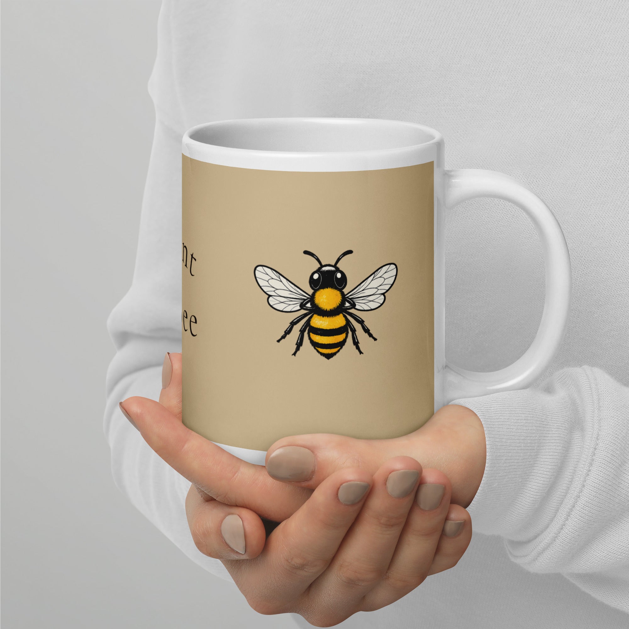 Beige ceramic mug with white handle and rim, yellow-and-black bee illustration on front