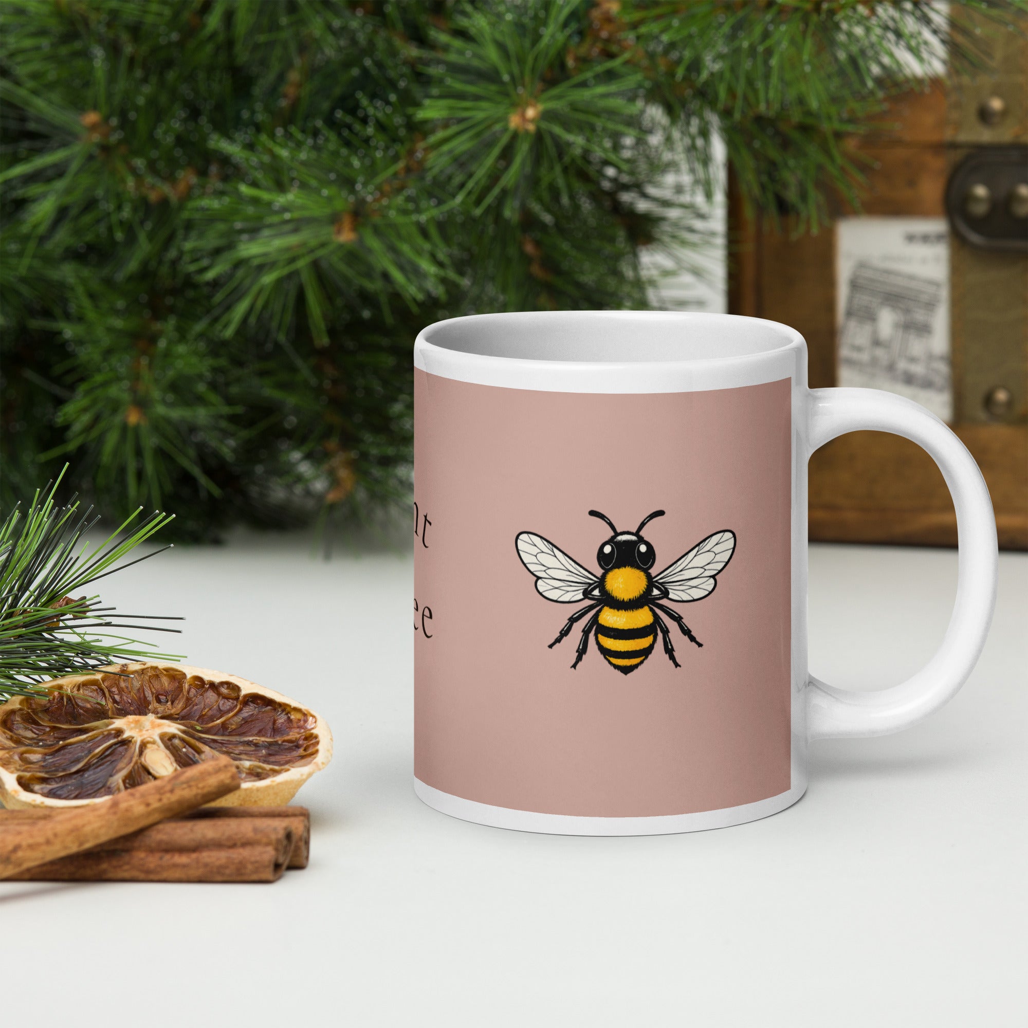 Dusty rose ceramic mug with white handle and centered bee illustration in black and yellow.
