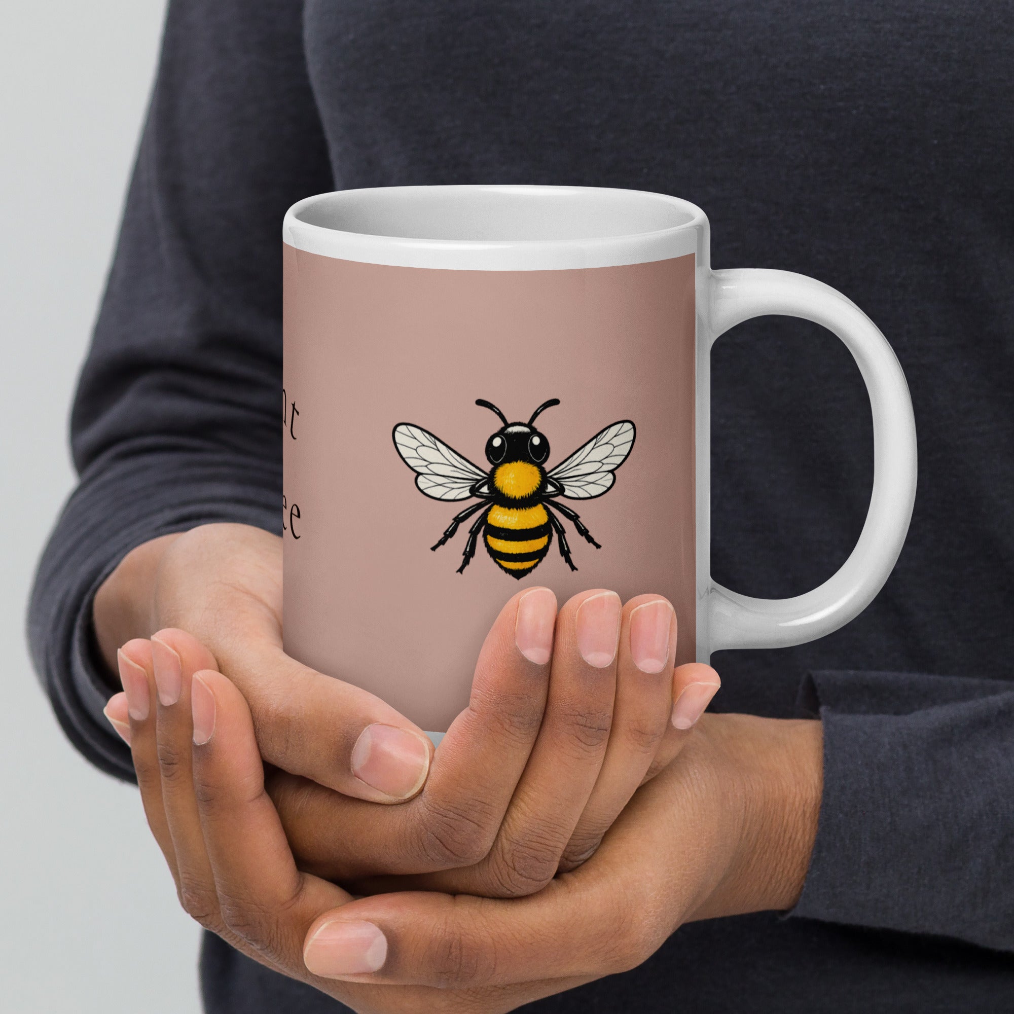 Dusty rose ceramic mug with white rim and handle, bee illustration on the front.