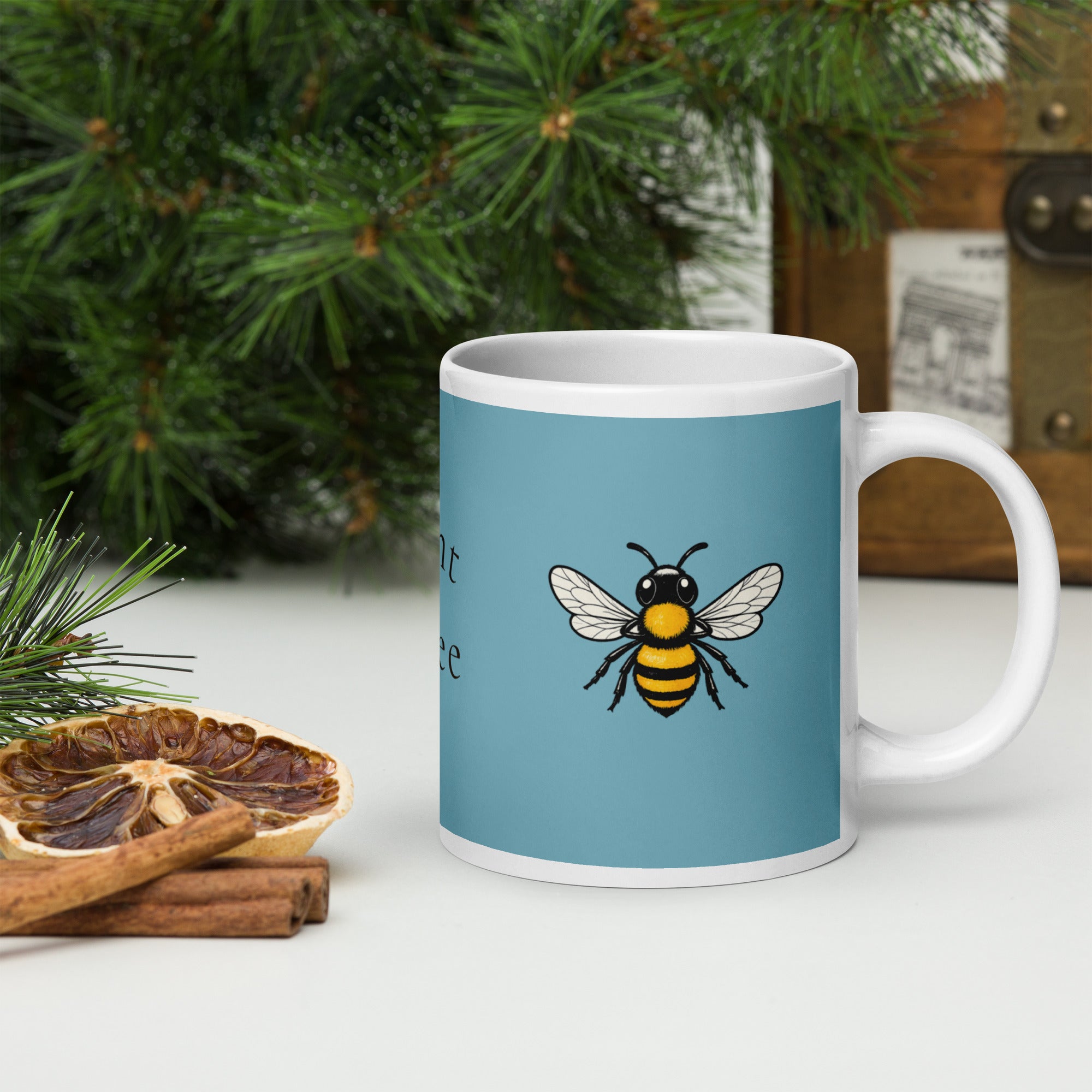 Blue ceramic coffee mug with bee illustration, white rim and handle.