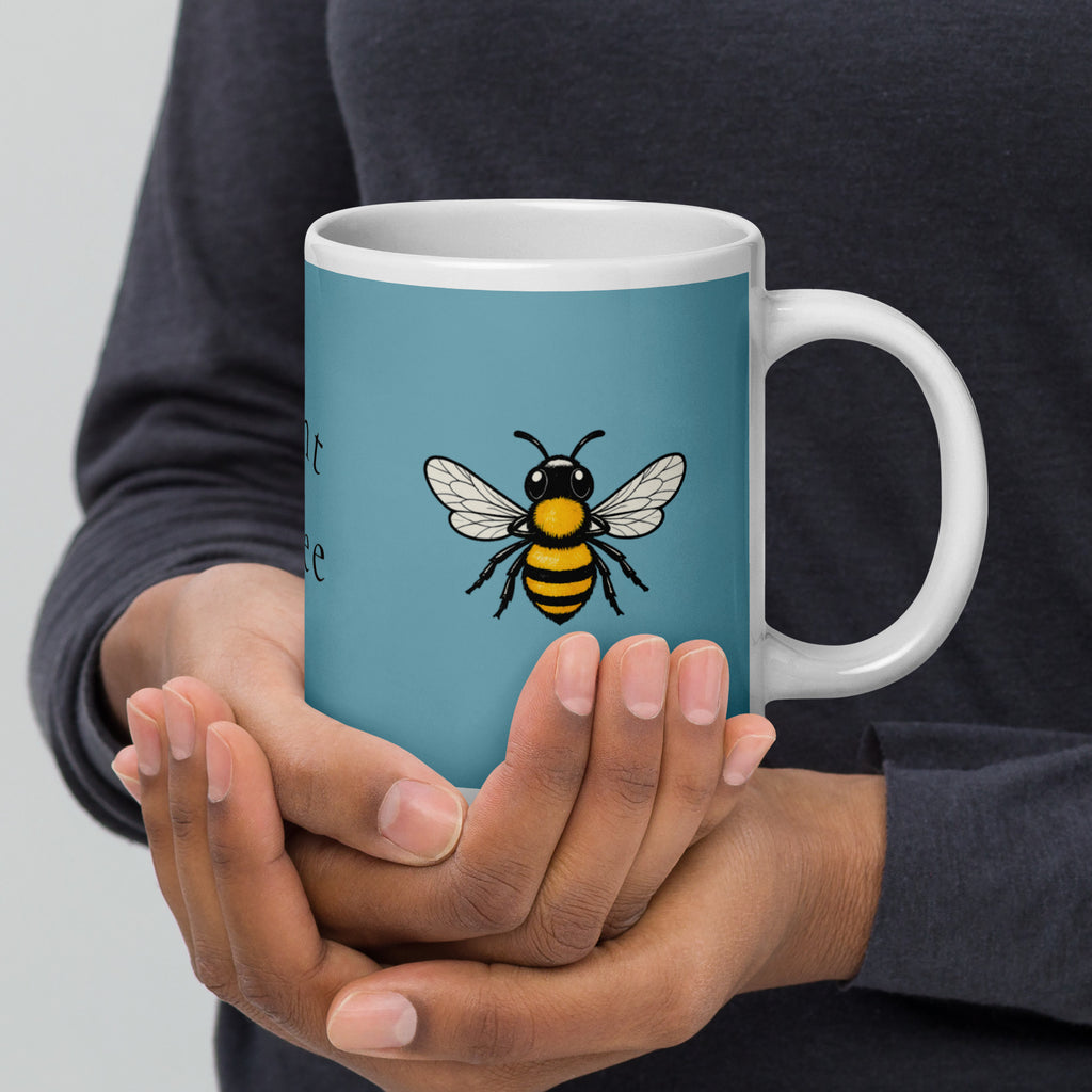 Blue ceramic mug with white rim and handle, bee illustration centered while held