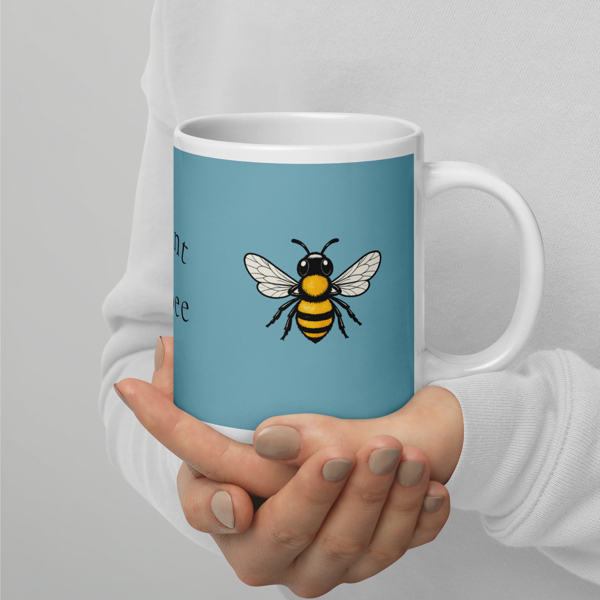 Blue ceramic mug with white rim and handle, bee illustration shown front and center
