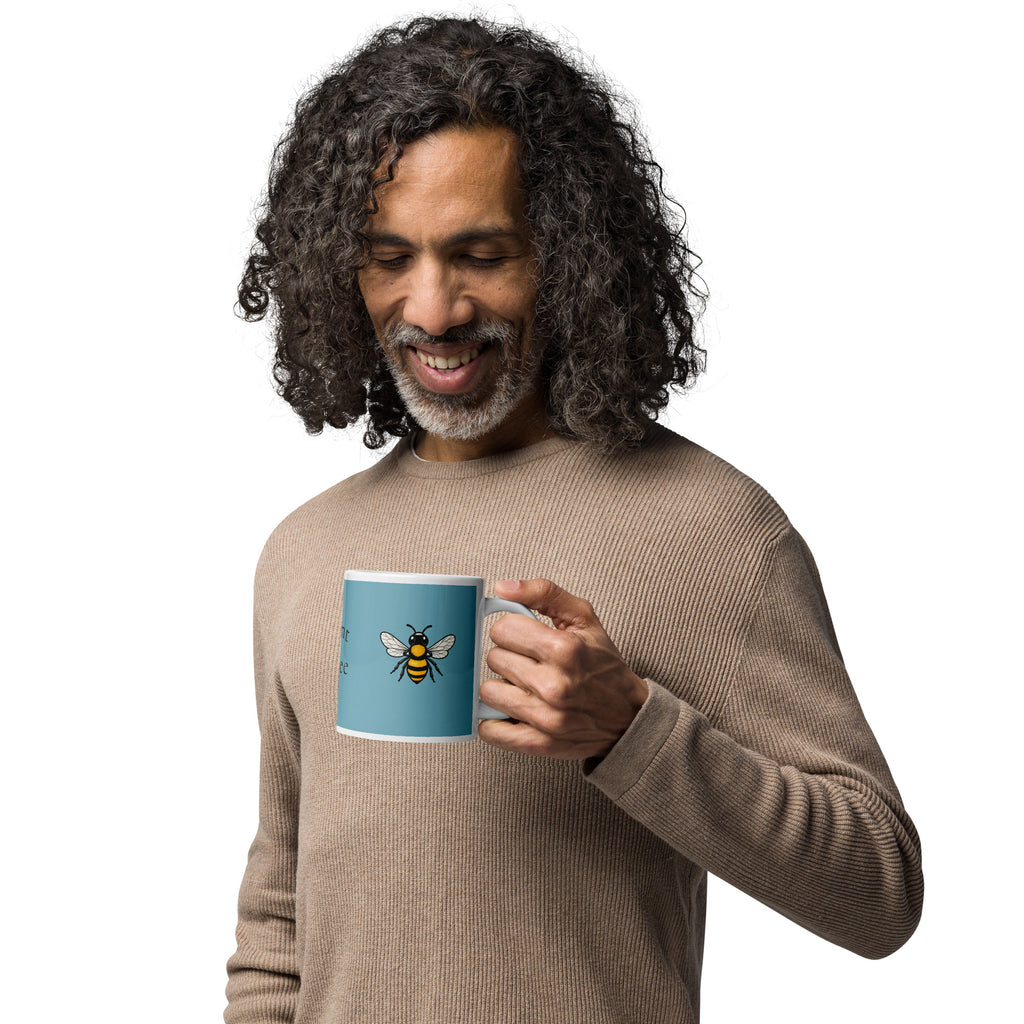 Blue ceramic coffee mug with bee illustration on front panel, white rim and handle