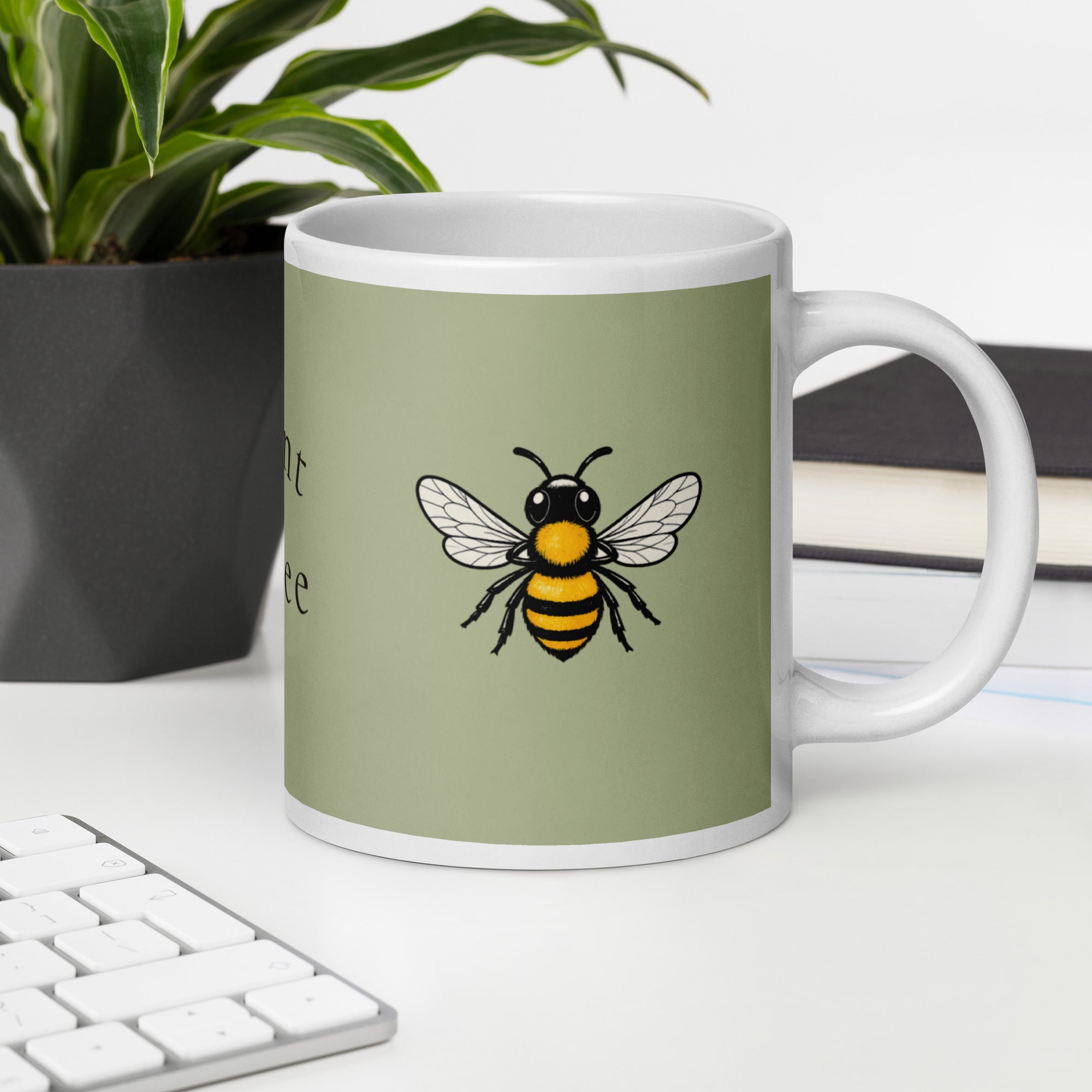 Sage green ceramic mug with white handle and central bee illustration on front