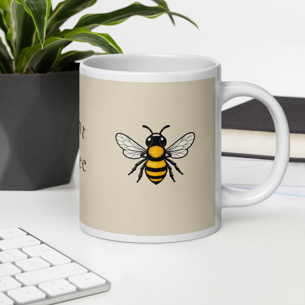 Light beige ceramic coffee mug with bee illustration, angled view